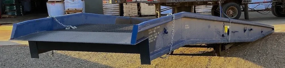 Portable steel yard ramp at a loading dock—industrial forklift ramp (not a wheelchair ramp).